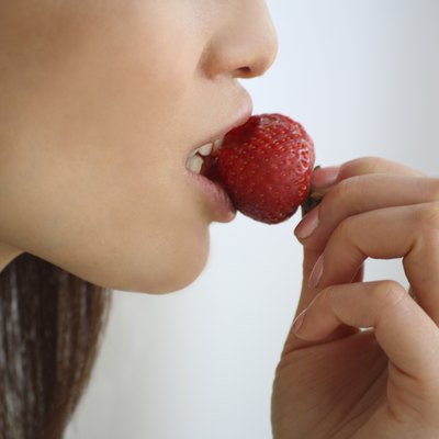 Close Up Image of a Woman Eating a Strawberry, Side View