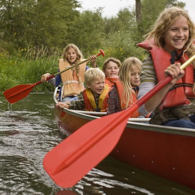 Siblings canoeing on river