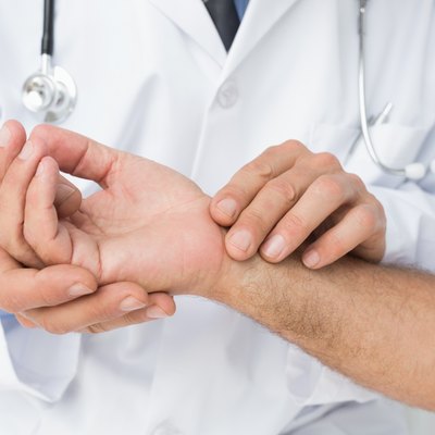 Mid section of a doctor taking a patients pulse