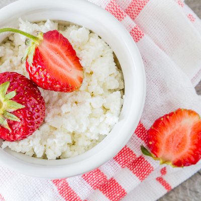 Cottage cheese in white bowl with strawberries, plaid napkin