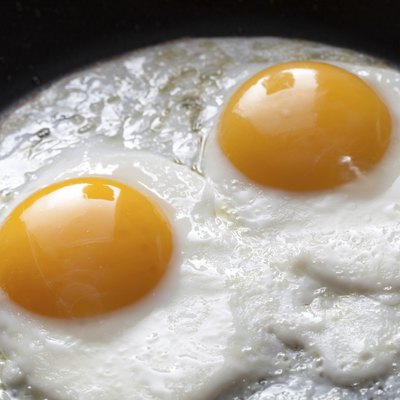 Closeup photo of two scrambled eggs in black frying pan
