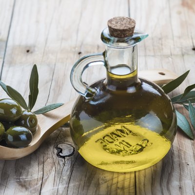 Olive oil bottle and a spoon with olives