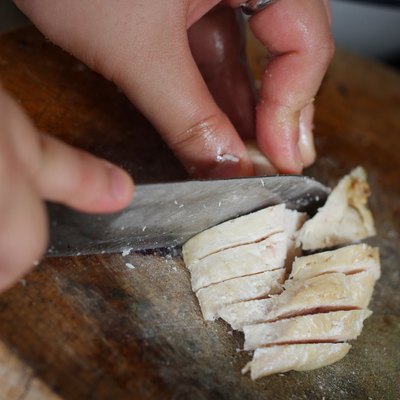 Chef silcing grilled chicken in the kitchen