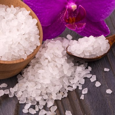 White bath salt in a wooden bowl