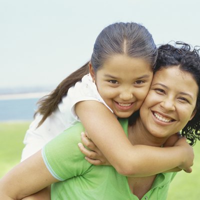 portrait of a daughter riding piggyback on her mother