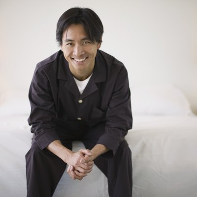 Smiling man sitting on edge of bed