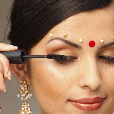 Woman with traditional bindi applying makeup