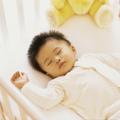 high angle view of a baby boy sleeping in a crib
