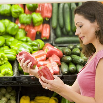 Woman shopping for bell peppers at a grocery store