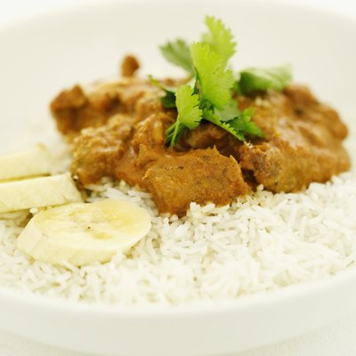 Close-up of a dish of rice and curry garnished with coriander and banana slices