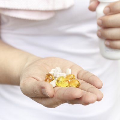 Woman hand with Cod liver oil and supplements