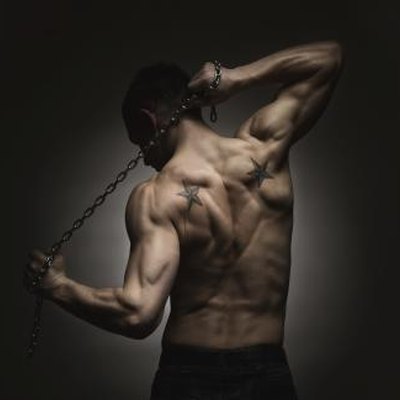 Rear view of muscular sports man stretching out over dark concrete background