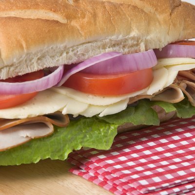 Sub sandwich on wooden cutting board with napkins