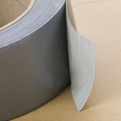 A roll of grey duct tape on a brown surface