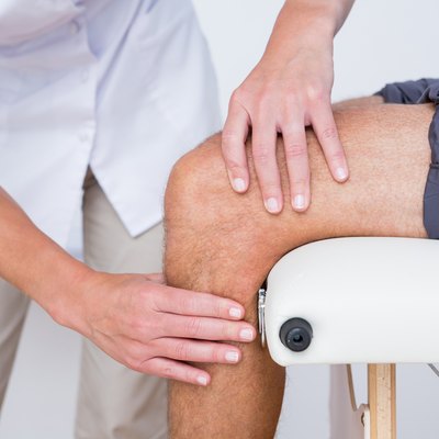 Doctor examining her patient knee