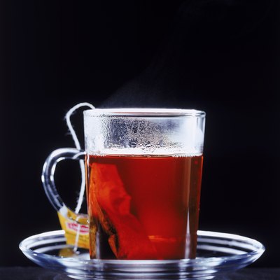Tea cup with tea bag on black background