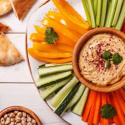 Homemade hummus with assorted fresh vegetables and pita bread.