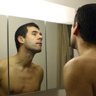Man's reflection in the bathroom mirror