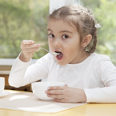 Little child eats yogurt