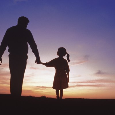 Silhouette of father and daughter walking