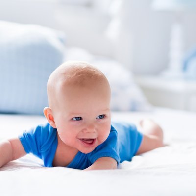 Baby boy in white sunny bedroom