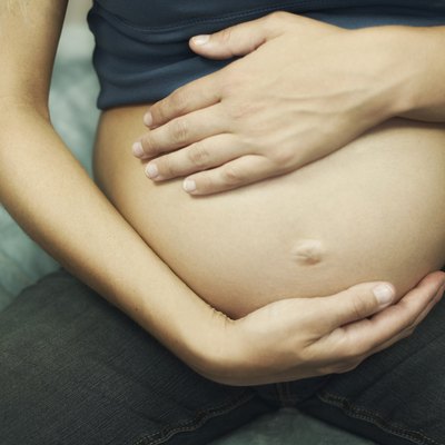 Cropped pregnant woman touching belly