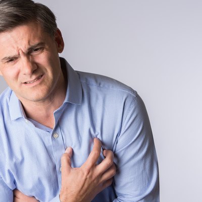 Studio Shot Of Mature Man Suffering Heart Attack