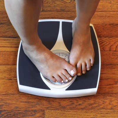 Woman on scale unhappy with her weight