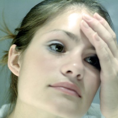 Close-up of a young woman touching her forehead