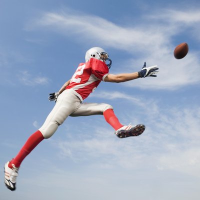 Football player in mid-air reaching for football
