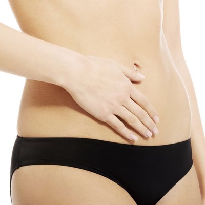 Caucasian woman is holding hand on her belly.