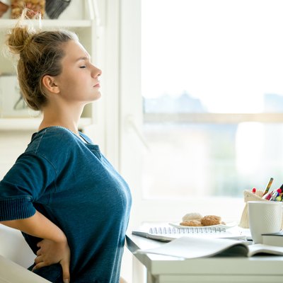 Portrait of an attractive woman at the table backache pose