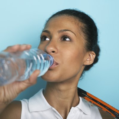Female tennis player drinking water