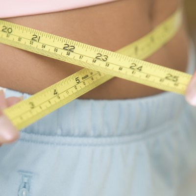 Closeup of teen girl measuring her waist