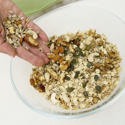 Woman mixing nuts into muesli, close up