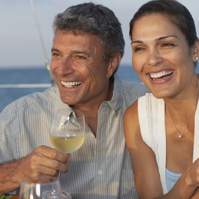 Multi-ethnic couple drinking wine on boat