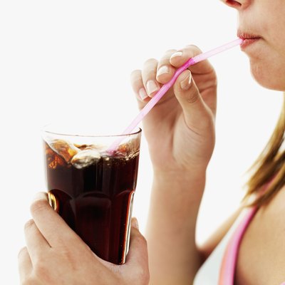 close-up of a teenage girl drinking cola with a straw
