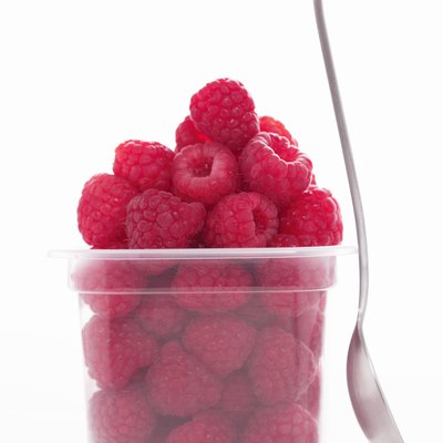 Punnet of raspberries by spoon, close-up