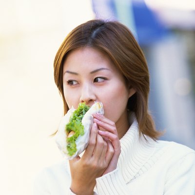 Young Adult Woman Eating a Sandwich, Front View