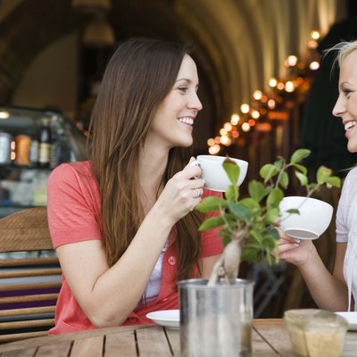 Women drinking coffee and chatting at cafe