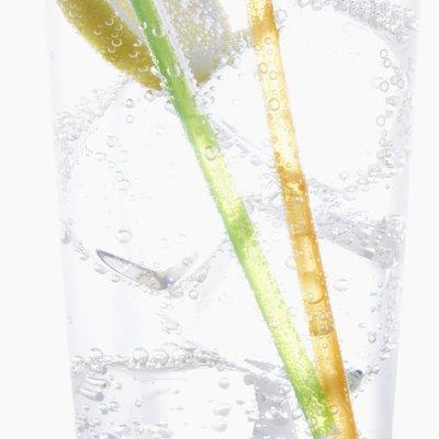 Straws, lemon and ice in carbonated water