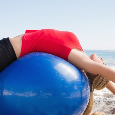 Fit blonde stretching back on exercise ball