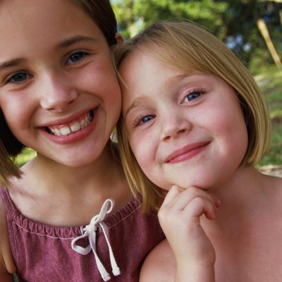Portrait of two girls (4-5,8-9) smiling