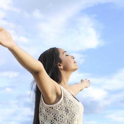 Portrait of arab woman breathing fresh air with raised arms