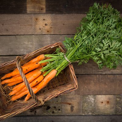 Bunch of carrots in basket, wood