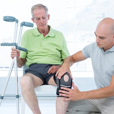 Doctor examining his patient knee