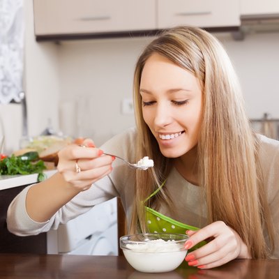 Happy woman eating cottage cheese