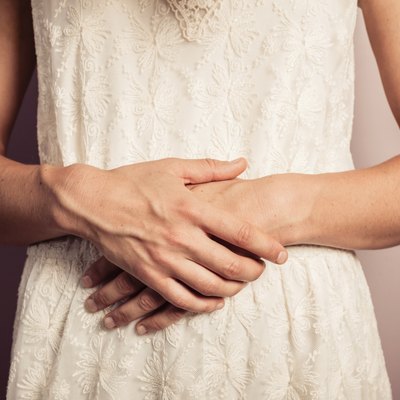 Young woman in white dress with stomach pains