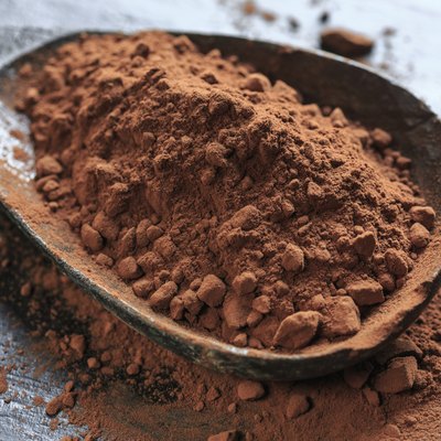 A large wooden spoonful of cacao powder.
