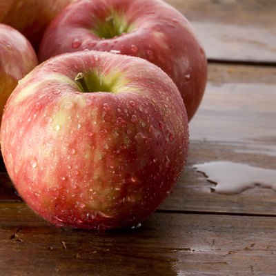 Honeycrisp apples on a wood background.
